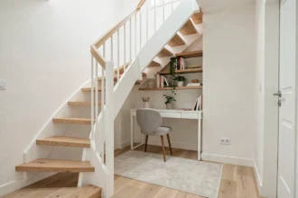 Espace sous escalier aménagé en bureau compact avec étagères en bois et chaise dans un intérieur scandinave moderne