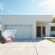 Garage moderne blanc avec personne tenant permis de construire